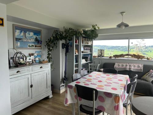 une salle à manger avec une table et un canapé dans l'établissement Les genêts, à Saint-Alban-sur-Limagnole