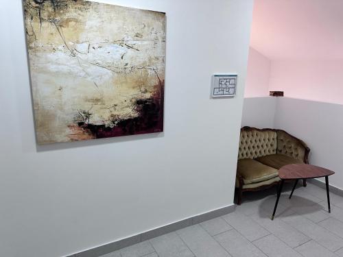 a bench in a room with a painting on the wall at Velora apartments in Subotica