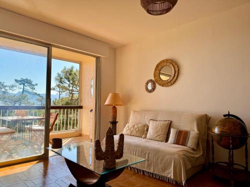 un salon avec un canapé et une table en verre dans l'établissement Logement pieds dans l'eau avec vue mer exceptionnelle, à Calvi