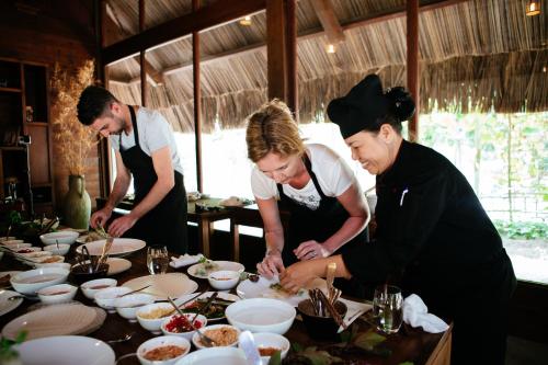 three people standing around a table preparing food at L'Alya Ninh Van Bay in Ninh Van Bay