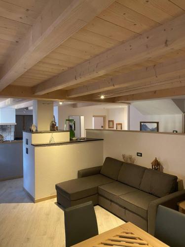 a living room with a couch and a kitchen at tabià piz meda in Moena