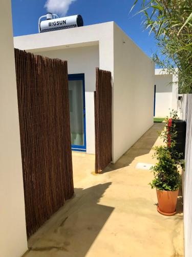 two tall wooden fences are on the side of a building at Nareia in Vila Nova de Milfontes