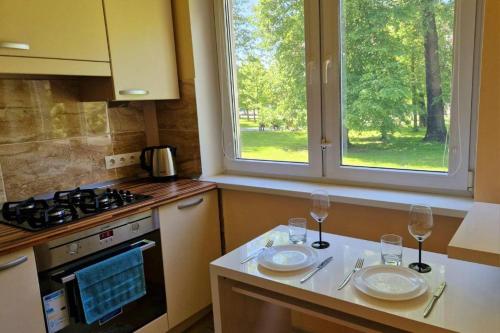a kitchen with two glasses of wine on a counter at Apartments next to Acropolis, self check inn in Klaipėda
