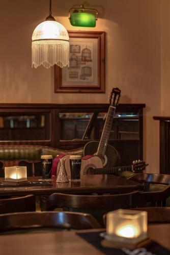 a restaurant with a table with a guitar on the wall at Hotel Aquamarin in Kühlungsborn