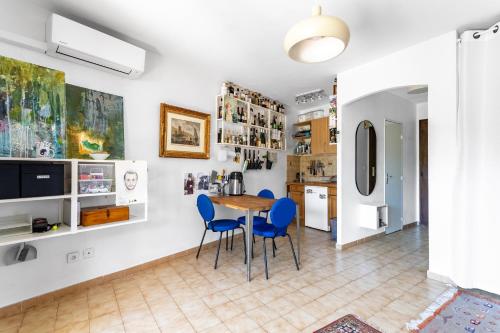 una cucina e una sala da pranzo con tavolo e sedie di Superbe T2 avec jardin, clim à 600m de la plage a Carqueiranne