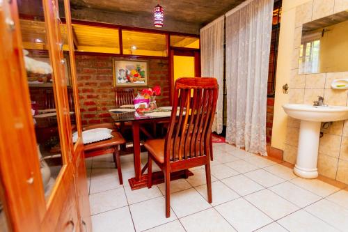 a bathroom with a table and a chair and a sink at Cozy Nature Escape in Moshi in Moshi