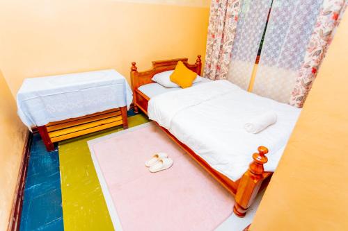 two beds in a small room with towels on the floor at Cozy Nature Escape in Moshi in Moshi