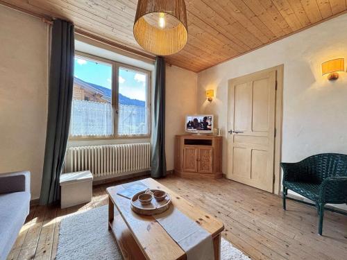 un salon avec une table et une grande fenêtre dans l'établissement Appartement cosy à Praz-Sur-Arly, proche pistes de ski, centre, parking, 2 étoiles, pour 4 pers. - FR-1-603-6, à Praz-sur-Arly