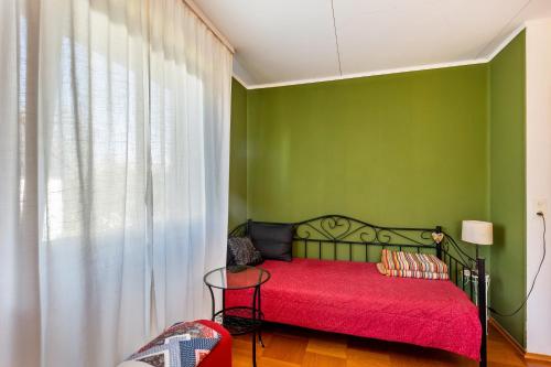 a green bedroom with a bed with a red blanket at Ferienwohnung Oberamsel in Marburg an der Lahn