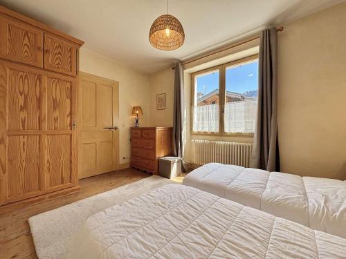 une chambre avec un grand lit et une fenêtre dans l'établissement Appartement cosy à Praz-Sur-Arly, proche pistes de ski, centre, parking, 2 étoiles, pour 4 pers. - FR-1-603-6, à Praz-sur-Arly