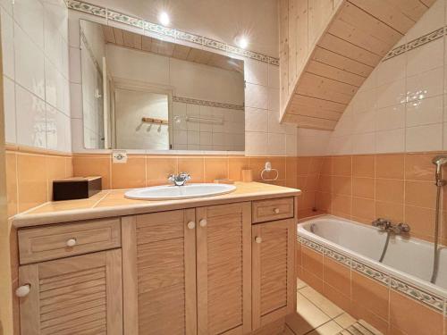 une salle de bain avec un lavabo, une baignoire et un miroir dans l'établissement Appartement cosy à Praz-Sur-Arly, proche pistes de ski, centre, parking, 2 étoiles, pour 4 pers. - FR-1-603-6, à Praz-sur-Arly