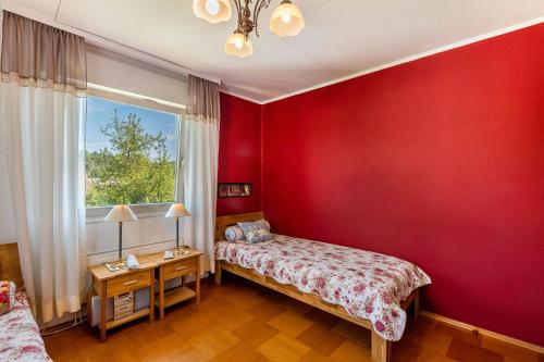 a bedroom with red walls and a bed and a window at Ferienwohnung Oberamsel in Marburg an der Lahn