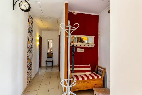 a hallway with a red wall with a chair and a clock at Ferienwohnung Oberamsel in Marburg an der Lahn