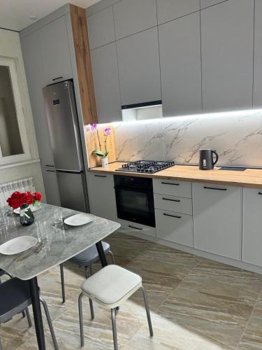 a kitchen with a table with chairs and a refrigerator at ЖК Central Park in Aktobe
