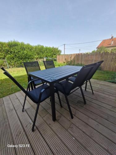 a picnic table and two chairs on a deck at Maison de village in Vesoul