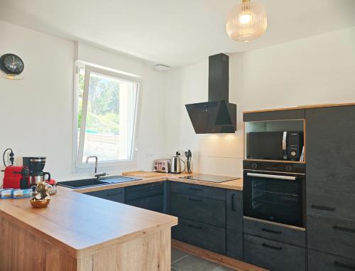 une cuisine avec des armoires bleues et un comptoir dans l'établissement La Maison des Écumes, à Crozon