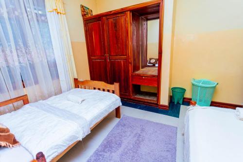 a small bedroom with a bed and a mirror at Cozy Nature Escape in Moshi in Moshi