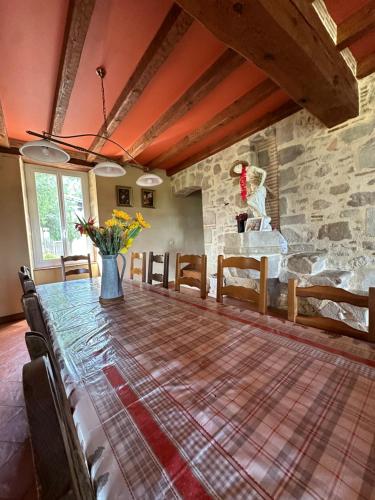 une salle à manger avec une table et un mur en pierre dans l'établissement Gîte Prestige avec Sauna, Spa, Piscine & Loisirs 15 pers, à Verteuil-dʼAgenais