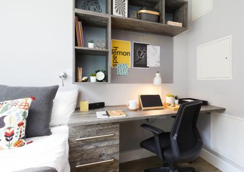 a bedroom with a desk and a bed with a laptop at For Students Only - Collegiate Crown Place Cardiff in Cardiff