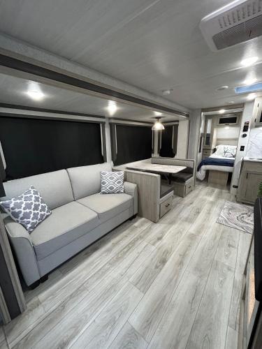 a living room with a couch and a bed at The Lake Escape RV Meets The Beach in Foley