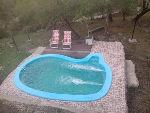 una piscina con 2 sillas y una piscina en Suspiro de Montaña, en La Rancherita