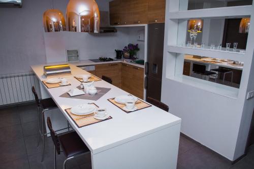 a kitchen with a white table with dishes on it at Tbilisi View Hotel in Tbilisi City