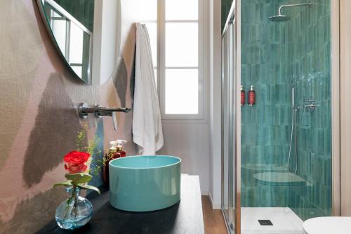 a bathroom with a large blue bath tub next to a shower at Elysium Boutique Apartments - Catania in Catania