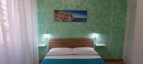 Ce lit se trouve dans une chambre dotée d'un mur vert. dans l'établissement Onda marina 1, à La Spezia