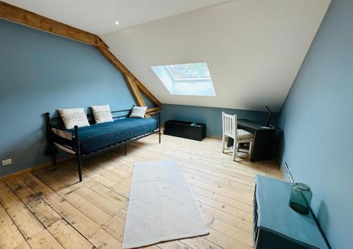 un salon avec un canapé bleu et une fenêtre dans l'établissement Les Monts, T7 duplex 4 étoiles Clé Vacances, à La Bresse