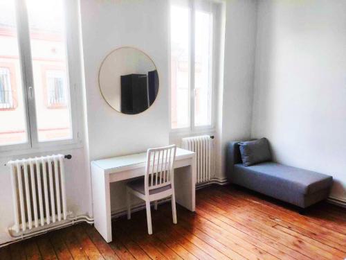une pièce avec un bureau, une chaise et un miroir dans l'établissement Appartement Grand Rond, à Toulouse