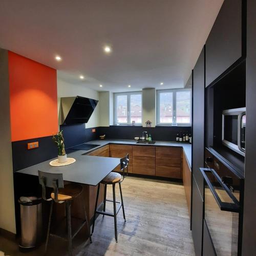 une cuisine avec une table et quelques chaises dans l'établissement Les Monts, T7 duplex 4 étoiles Clé Vacances, à La Bresse