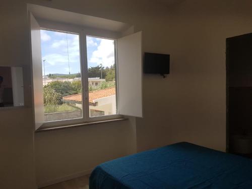 a bedroom with a window and a bed and a television at Golden River n1 Marina di Campo in Campo nell'Elba