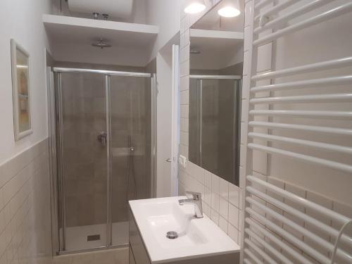 a white bathroom with a shower and a sink at Golden River n1 Marina di Campo in Campo nell'Elba