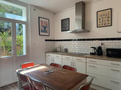 une cuisine avec une table en bois et des chaises rouges dans l'établissement Le sud version toulouse, à La Seyne-sur-Mer