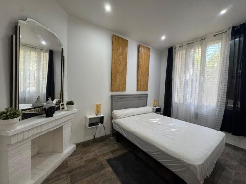 une chambre avec un grand lit et un miroir dans l'établissement Le sud version toulouse, à La Seyne-sur-Mer