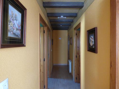a hallway with yellow walls and wooden ceilings at Pensión la Campanilla in La Penilla
