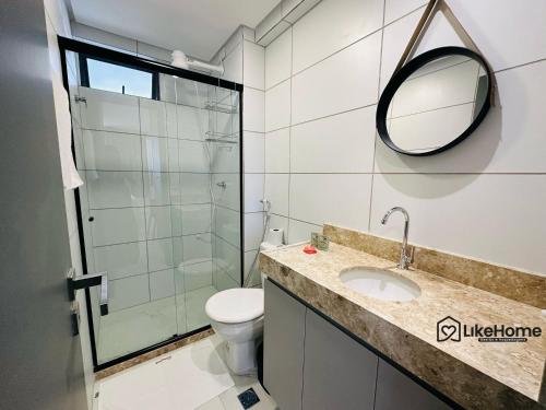 a bathroom with a toilet sink and a mirror at Edifício Mindset - LikeHome Hospedagens in João Pessoa