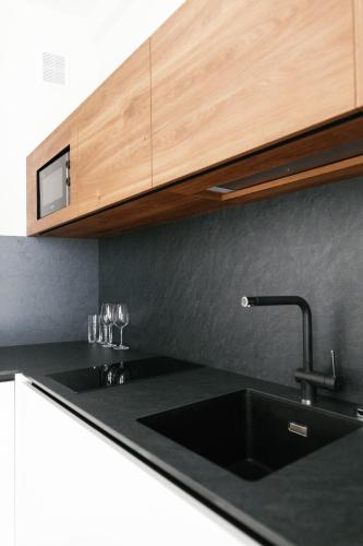 a kitchen with a black sink and a wooden cabinet at Select Hotel in Lviv