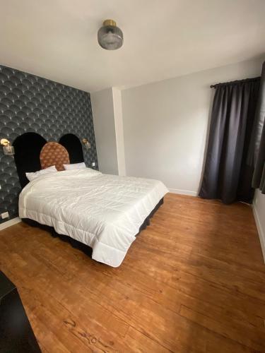 une chambre avec un lit et un parquet dans l'établissement Juvanedi, à Rouen
