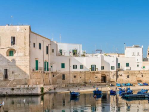 un grupo de barcos en el agua junto a los edificios en Sea View Romantic Apartments Al Vecchio Porto, en Monopoli