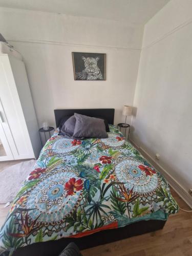 une chambre avec un lit avec une couette colorée dans l'établissement Bobillot, à Paris