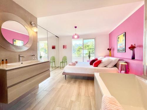 une chambre avec un lit, une baignoire et un lavabo dans l'établissement Royal Pink - Appartement design - Vue de rêve - Parking gratuit, à Cannes
