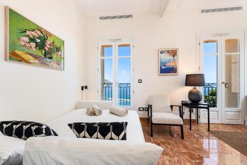 - un salon blanc avec un canapé et une chaise dans l'établissement MAISON GARAVAN - Somptueux 2 pièces - Vue Mer - Menton, à Menton