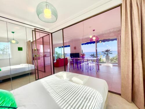 une chambre avec un lit et un balcon avec une table dans l'établissement Royal Pink - Appartement design - Vue de rêve - Parking gratuit, à Cannes