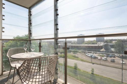 a balcony with a table and chairs and a view of a highway at Stunning 1 Bedroom Apartment in Central Sheffield in Sheffield