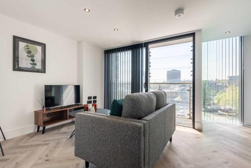 a living room with a couch and a television at Stunning 1 Bedroom Apartment in Central Sheffield in Sheffield