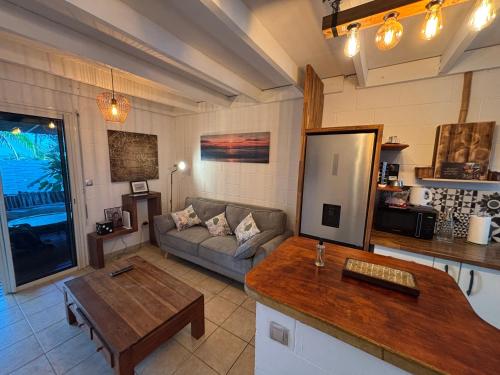 a living room with a couch and a table at Villa Pétrel in Saint-Paul
