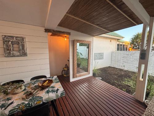 a patio with a table and chairs on a deck at Villa Pétrel in Saint-Paul