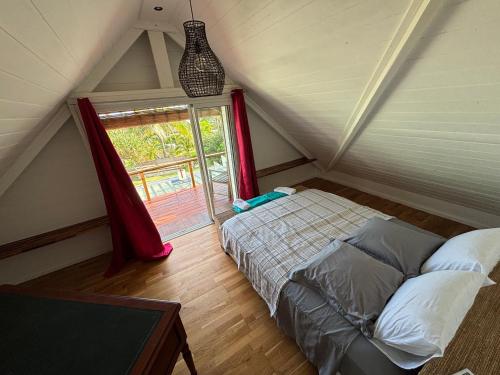 a attic bedroom with a bed and a window at Villa Pétrel in Saint-Paul