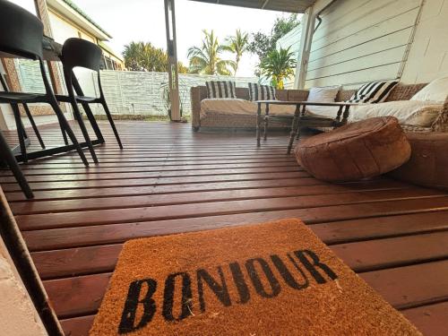a rug on a deck with chairs and a table at Villa Pétrel in Saint-Paul